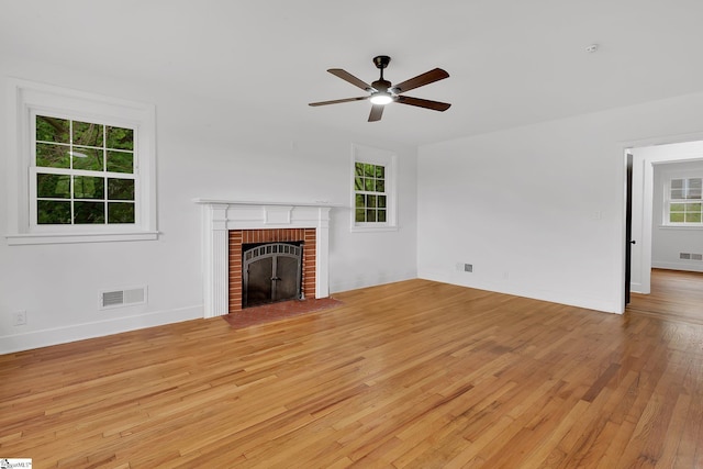 3902 Old Buncombe Rd, Greenville, SC 29617 - unfurnished living room with light wood-style flooring, ceiling fan, a fireplace, and baseboards