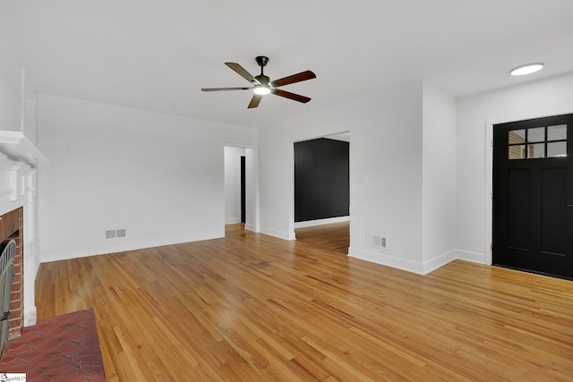 3902 Old Buncombe Rd, Greenville, SC 29617 - unfurnished living room with ceiling fan, a brick fireplace, light wood-type flooring, and baseboards