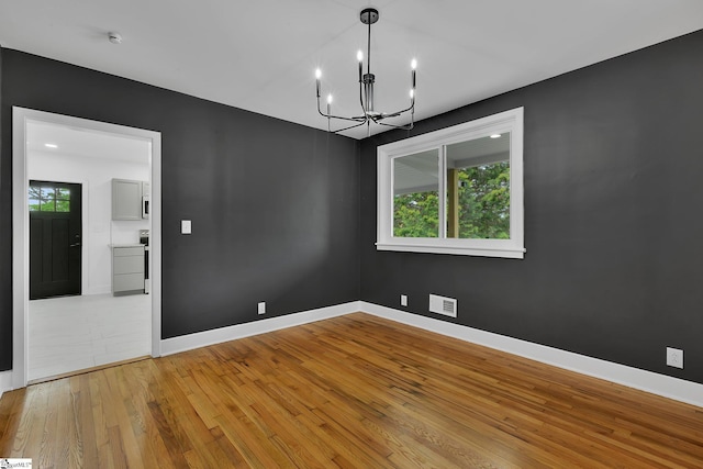 3902 Old Buncombe Rd, Greenville, SC 29617 - empty room with a chandelier, light wood-style flooring, and baseboards