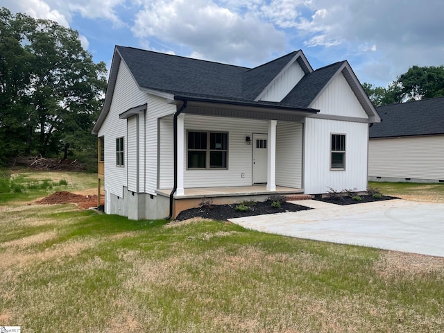 modern farmhouse style home with a porch, roof with shingles, and a front lawn