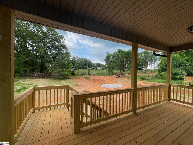 wooden deck with view of scattered trees