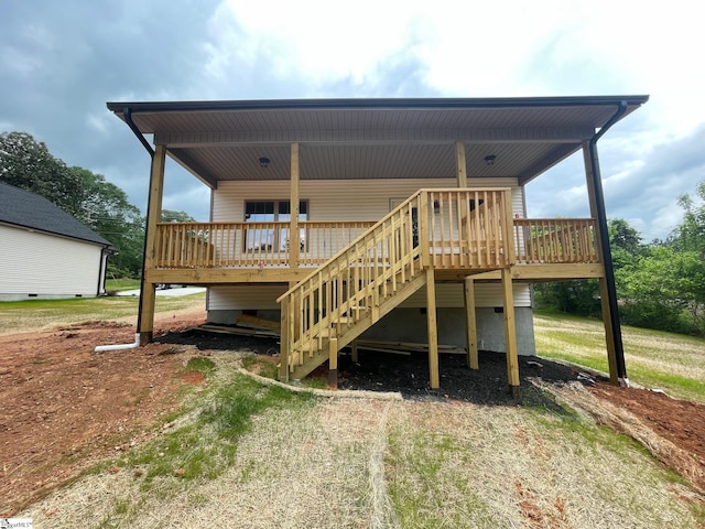 back of property with a wooden deck and stairs