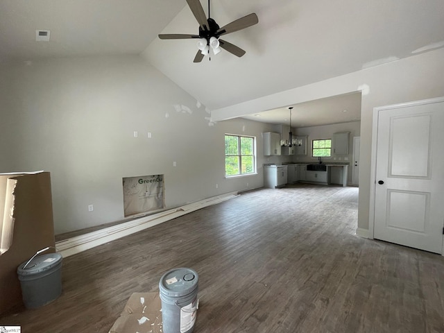 unfurnished living room with ceiling fan, wood finished floors, a chandelier, high vaulted ceiling, and a sink