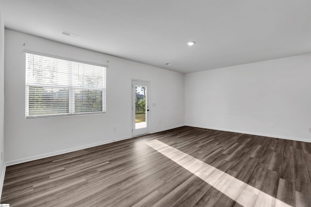 spare room featuring wood finished floors, baseboards, and recessed lighting