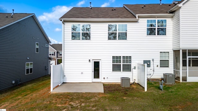 rear view of property with a patio, central air condition unit, a yard, and a shingled roof
