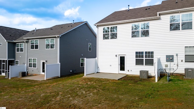 rear view of house featuring a patio area, central AC, and a lawn