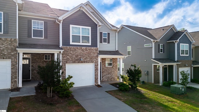 view of property featuring driveway, brick siding, and an attached garage