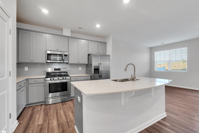 kitchen featuring stainless steel appliances, gray cabinets, a sink, and recessed lighting