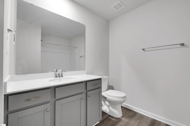 full bathroom featuring wood finished floors, toilet, vanity, and baseboards