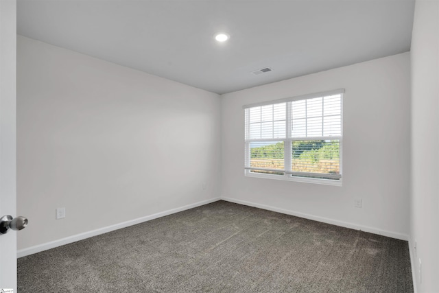 spare room featuring dark colored carpet, baseboards, and recessed lighting
