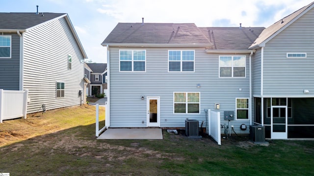 back of property with cooling unit, a patio, and a yard