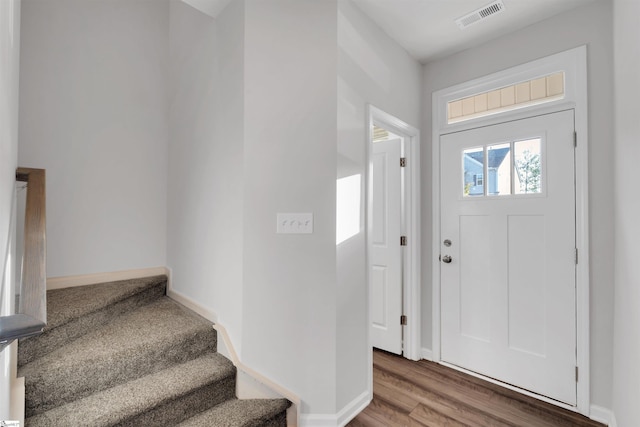 foyer featuring stairway, baseboards, and wood finished floors