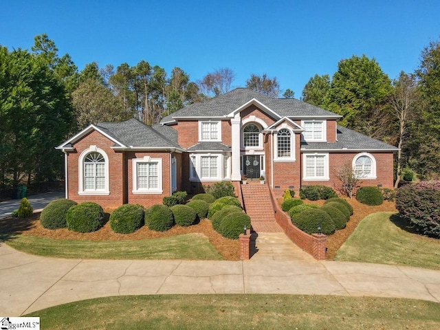 traditional-style home with brick siding and a front yard