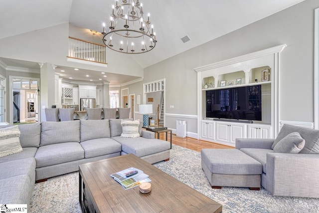 living room with high vaulted ceiling, a chandelier, and light wood-type flooring