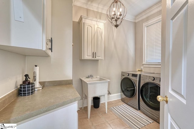 laundry area featuring separate washer and dryer, cabinet space, a chandelier, ornamental molding, and baseboards