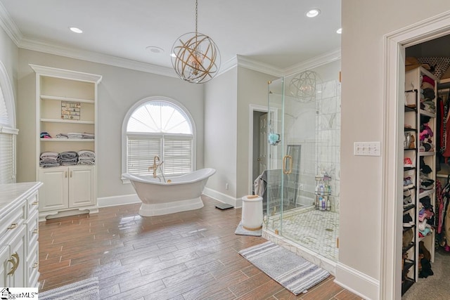 bathroom featuring a shower stall, ornamental molding, a spacious closet, a freestanding bath, and wood finished floors