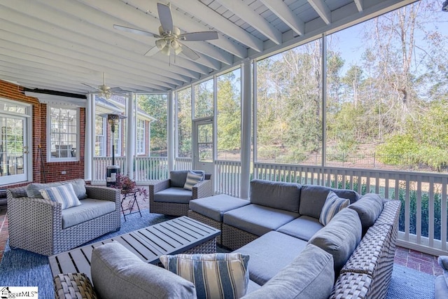 sunroom featuring an outdoor living space, ceiling fan, and beamed ceiling