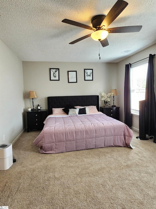 carpeted bedroom with a textured ceiling and a ceiling fan