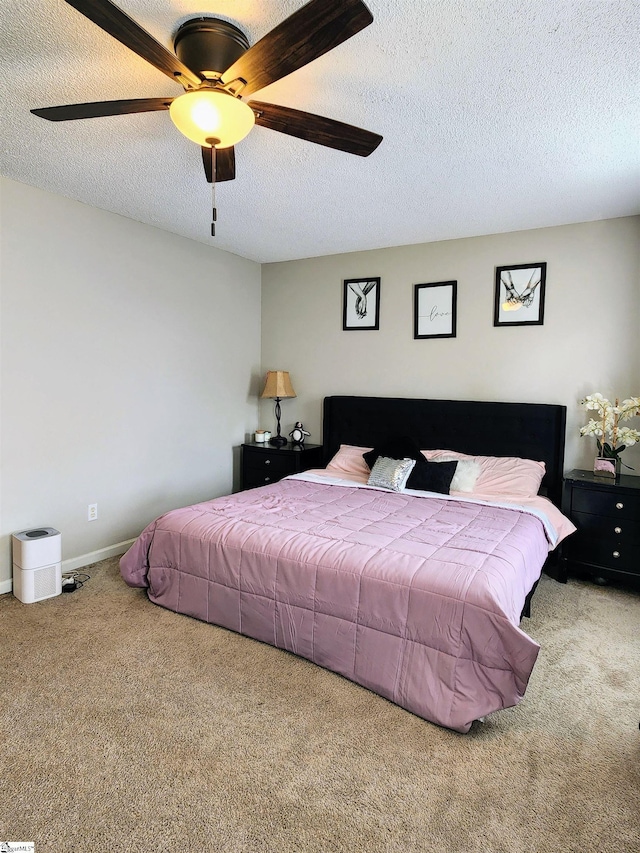 bedroom featuring carpet floors, a textured ceiling, a ceiling fan, and baseboards