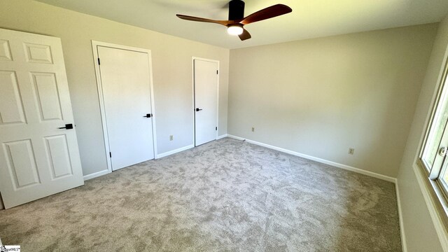 unfurnished bedroom with carpet, baseboards, and a ceiling fan