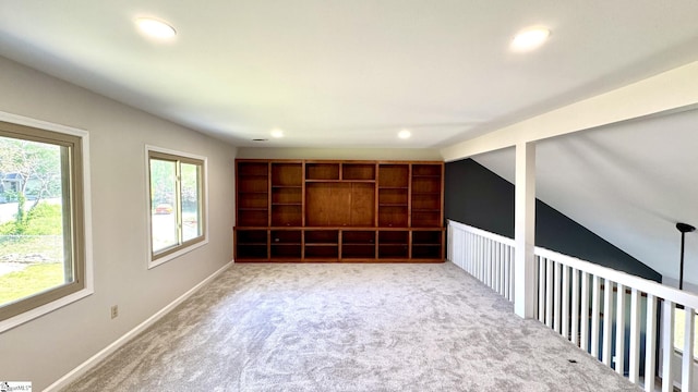 carpeted spare room featuring recessed lighting, vaulted ceiling, and baseboards