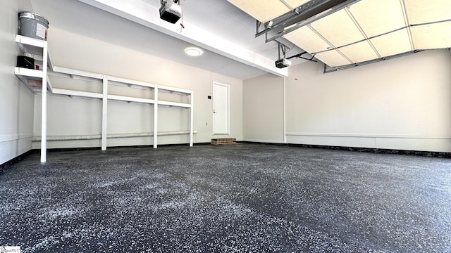 garage with a garage door opener and baseboards