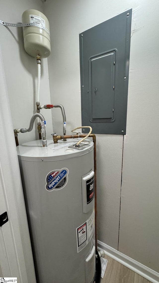 utility room with electric panel and water heater
