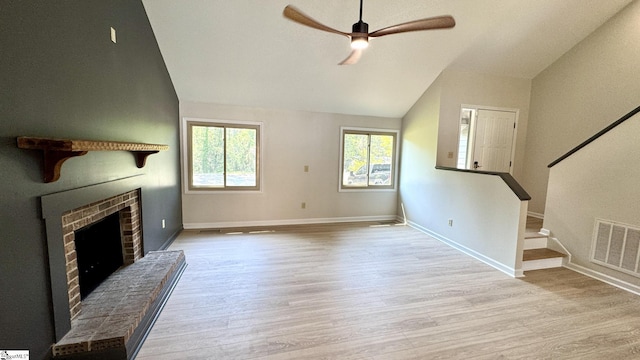 unfurnished living room featuring vaulted ceiling, wood finished floors, a ceiling fan, and plenty of natural light