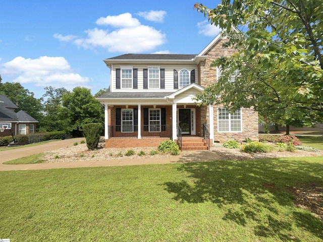 view of front of home featuring stone siding, a front lawn, and covered porch