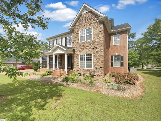 view of front of house featuring stone siding, a front yard, and a porch