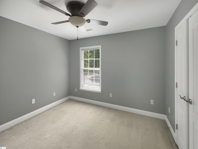 unfurnished bedroom featuring baseboards, light colored carpet, and ceiling fan