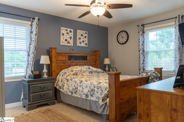 bedroom featuring light colored carpet, baseboards, and ceiling fan
