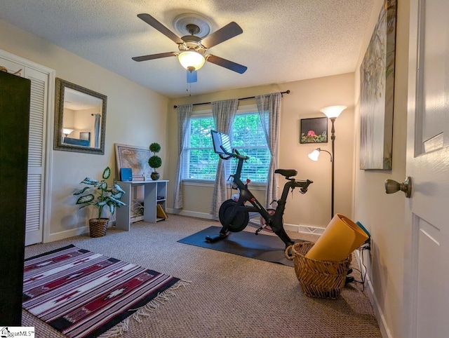 workout room with carpet flooring, ceiling fan, baseboards, and a textured ceiling