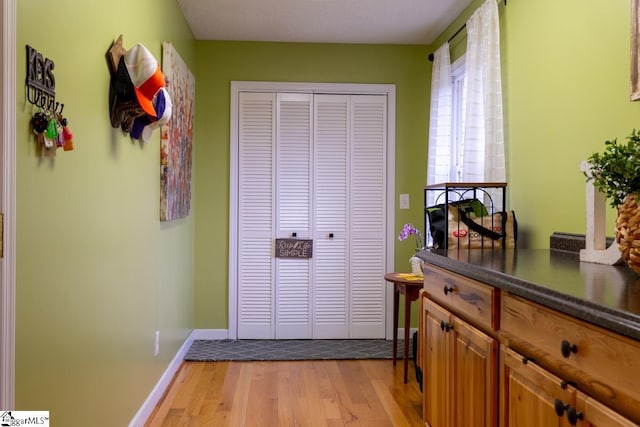 entryway with light wood-style flooring and baseboards