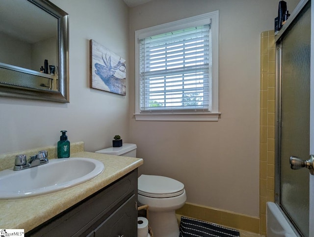 bathroom with toilet, vanity, and combined bath / shower with glass door