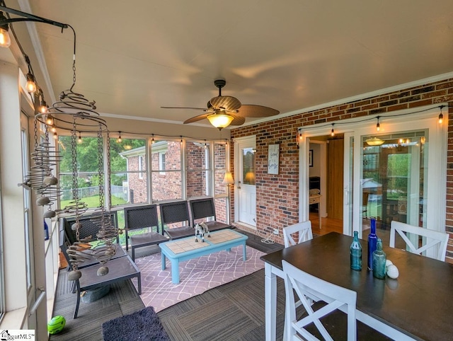 sunroom featuring a ceiling fan and outdoor dining area