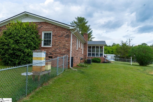 view of home's exterior featuring brick siding, central air condition unit, a chimney, and a sunroom