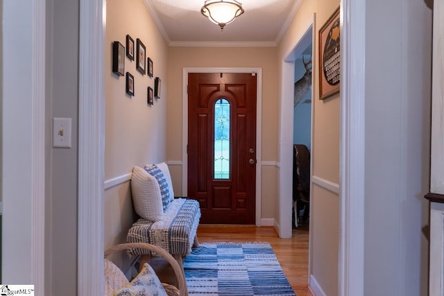 doorway to outside with light wood-type flooring and crown molding