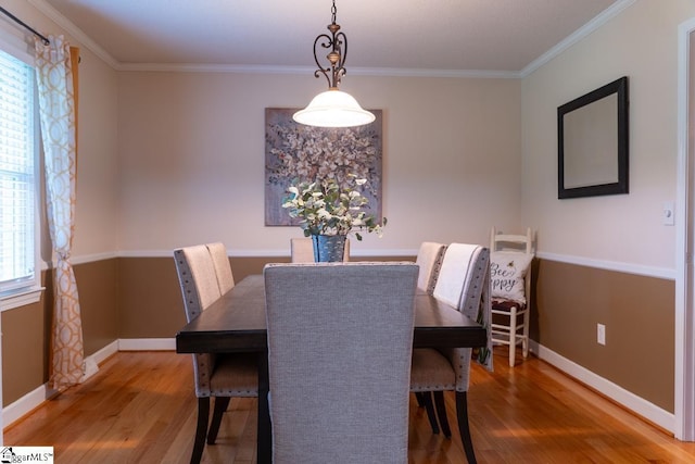 dining area featuring wood finished floors, baseboards, and ornamental molding