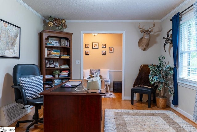 office with light wood-style floors, crown molding, baseboards, and a textured ceiling