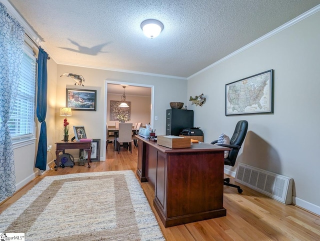 office space featuring a textured ceiling, light wood-type flooring, crown molding, and baseboards