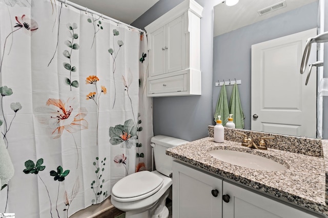 bathroom with toilet, vanity, and curtained shower