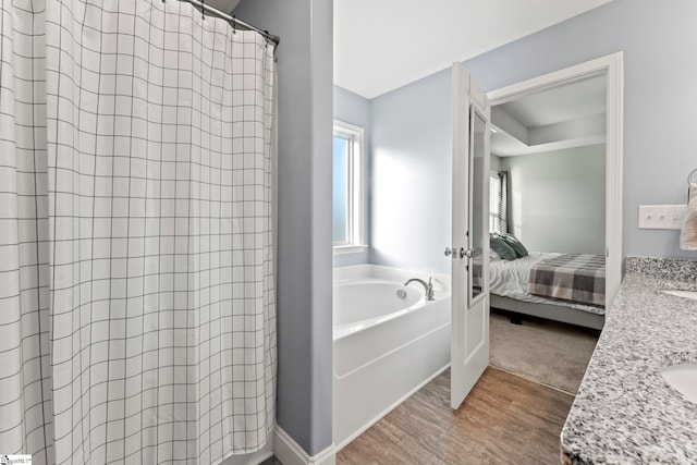 bathroom featuring wood finished floors, ensuite bathroom, a garden tub, french doors, and curtained shower