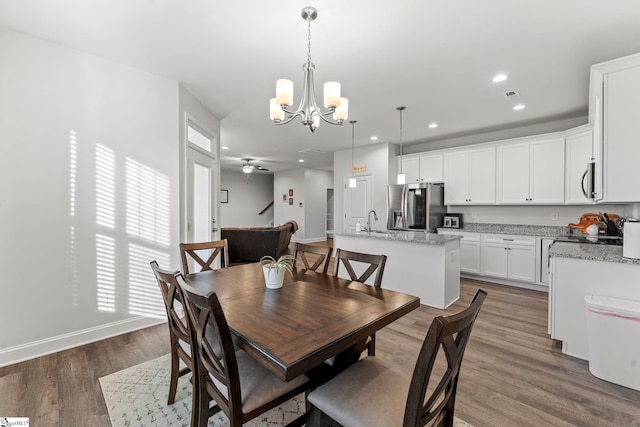dining space with a chandelier, wood finished floors, recessed lighting, baseboards, and ceiling fan
