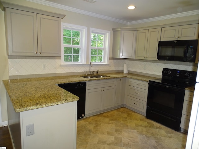 kitchen with black appliances, a sink, a peninsula, light stone countertops, and backsplash