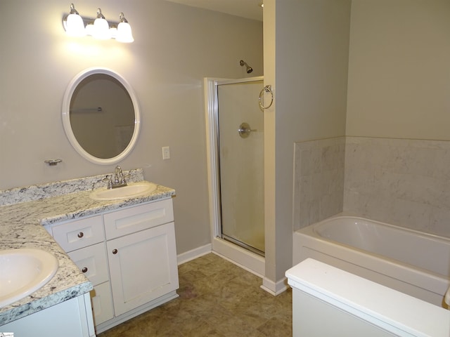 bathroom featuring a stall shower, vanity, a bath, and baseboards