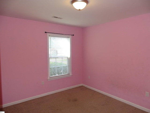 carpeted spare room featuring baseboards