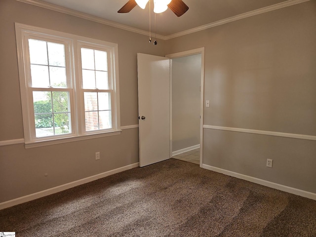 carpeted empty room with ceiling fan, ornamental molding, and baseboards