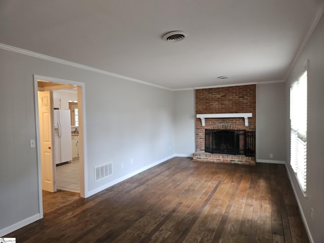unfurnished living room featuring dark wood finished floors, crown molding, baseboards, a fireplace, and plenty of natural light