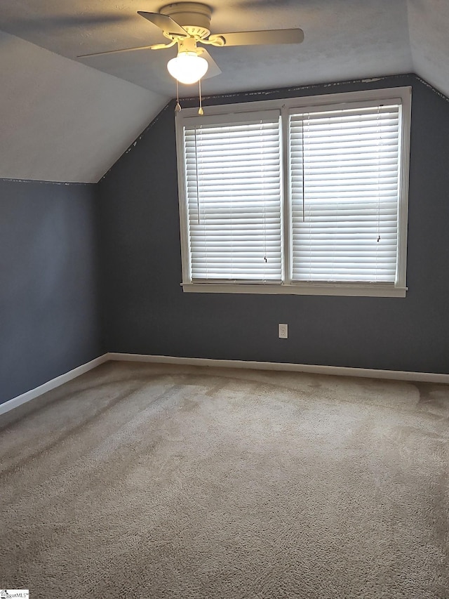 additional living space featuring lofted ceiling, carpet, baseboards, and ceiling fan